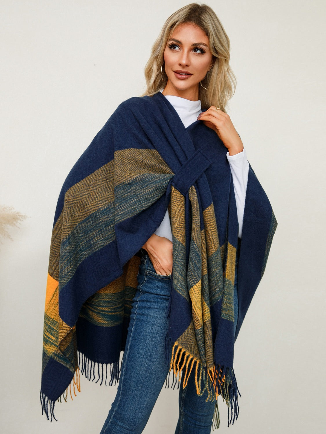 Navy plaid fringe cape with asymmetric cut and tie detail.