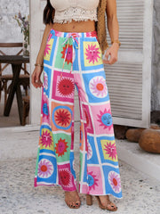 Geometric print wide-leg trousers with drawstring waist in multicolor sun pattern.