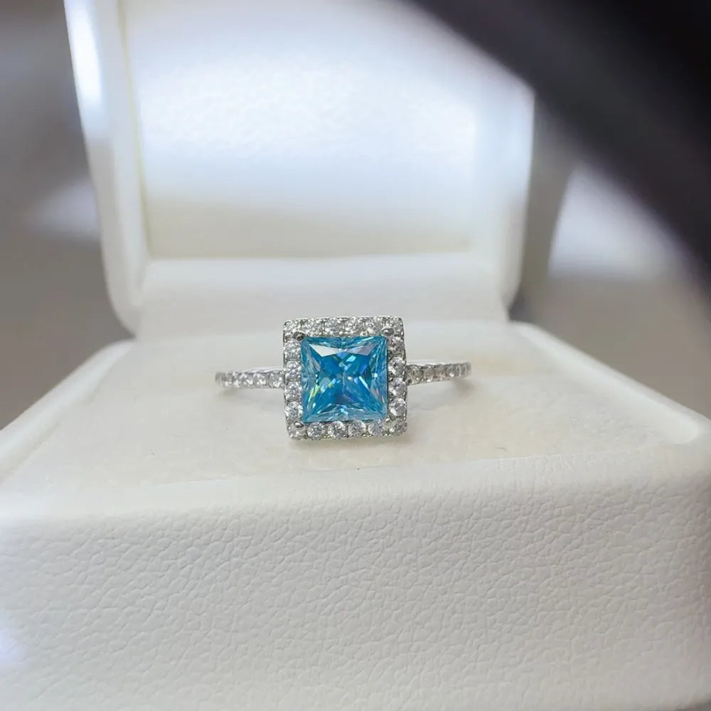 Silver ring with ice blue square halo center stone and diamond band