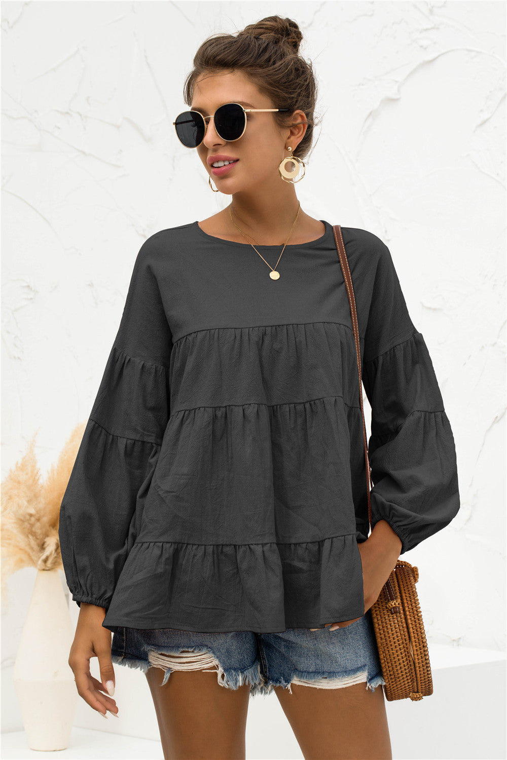 Black tiered peasant blouse with long bubble sleeves and round neckline.