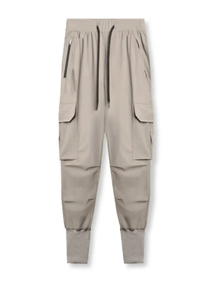 Technical cargo joggers in mocha with ribbed cuffs and zip pockets.