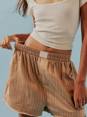 Tan pinstripe boxer shorts with elastic waistband and drawstring detail.