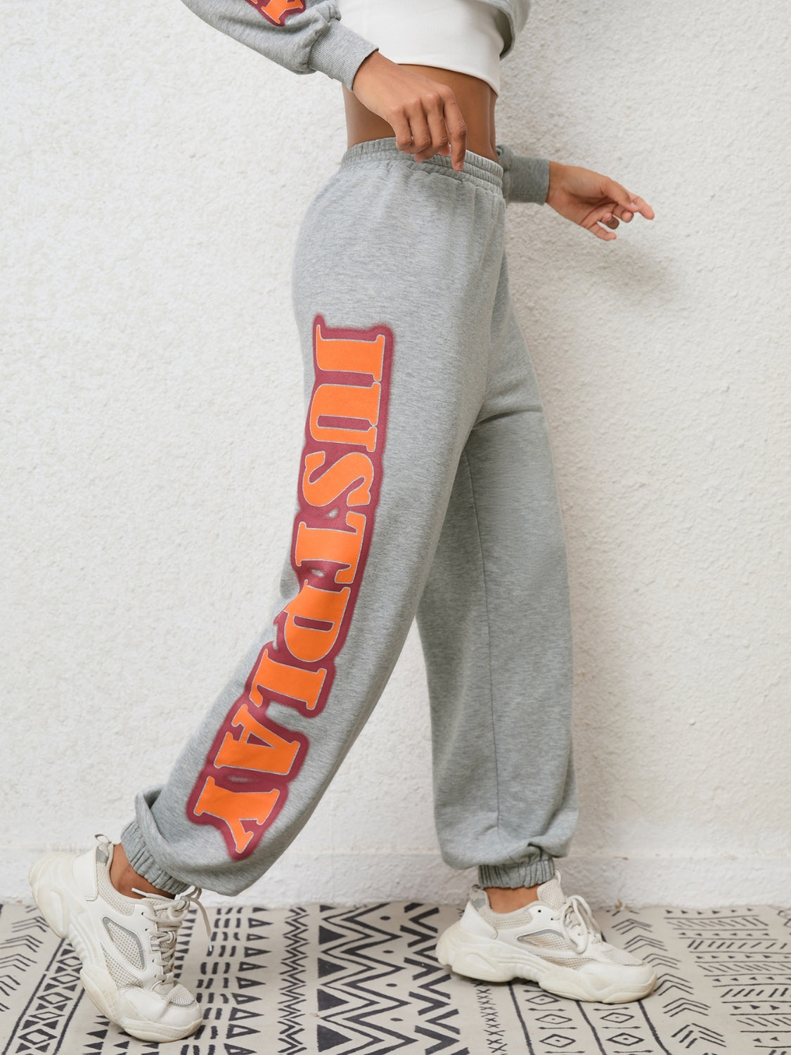 Heather Gray sweatpants with orange and red graphic text down the leg.