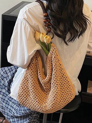 Khaki textured knit shoulder bag with wooden bead handle and ring detail.