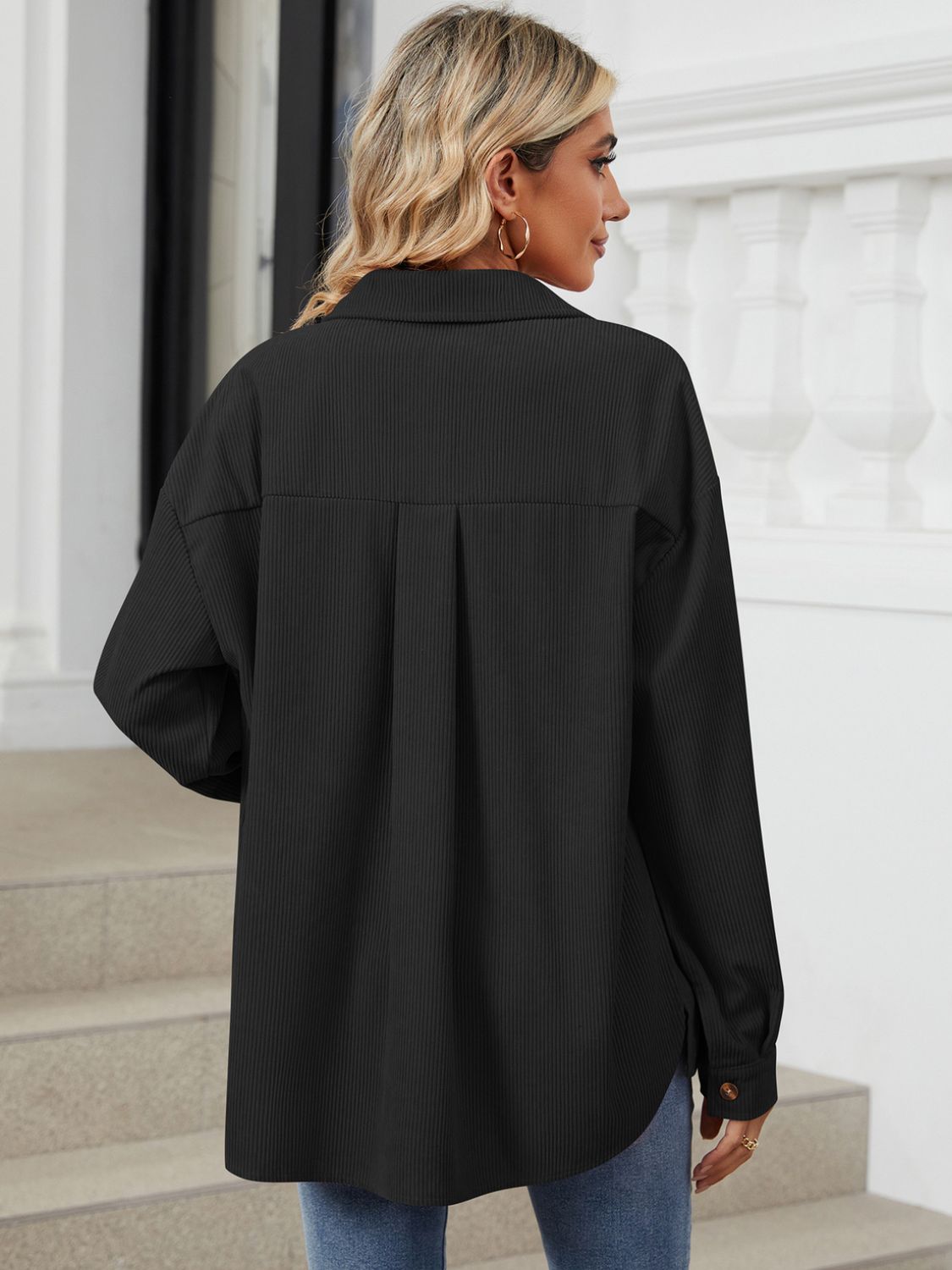 Black corduroy overshirt with patch pockets and button detail, shown from the back.