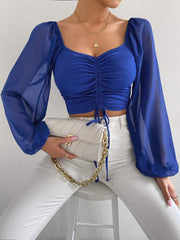Royal blue ruched bodice crop top with puff sleeves and drawstring detail.