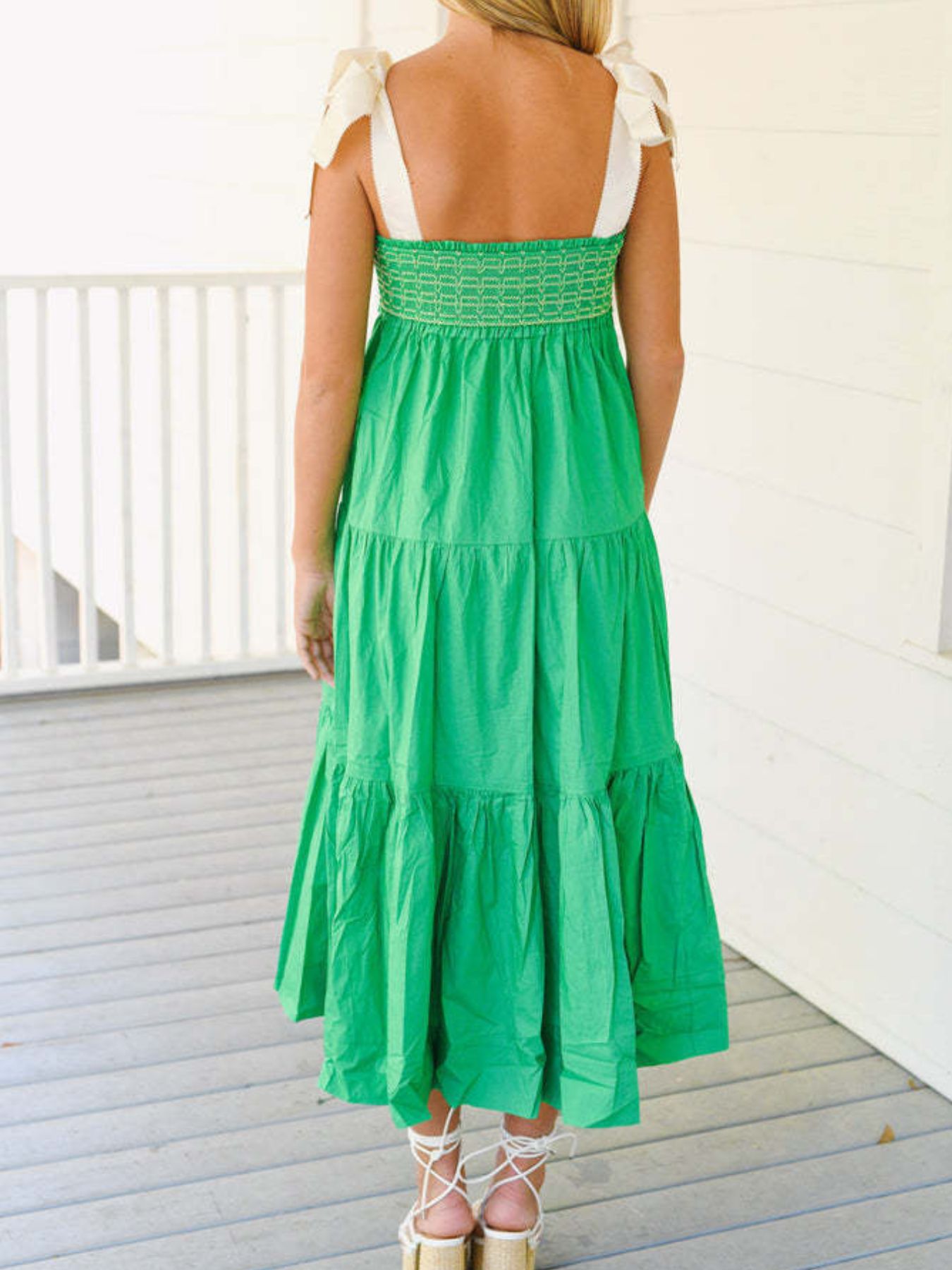 Green tiered midi dress with smocked bodice and tie shoulder straps.