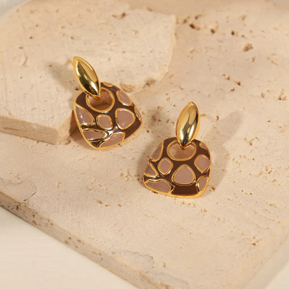 Geometric enamel drop earrings in brown and tan with gold accents.