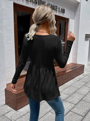 Black waffle knit peplum top with long sleeves and a gathered waist