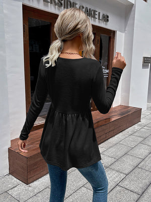 Black waffle knit peplum top with long sleeves and a gathered waist
