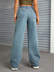 Distressed flare denim jeans in medium wash with raw edge detail and wide leg.