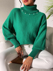 Green knit sweater with pearl-embellished turtleneck and dolman sleeves.