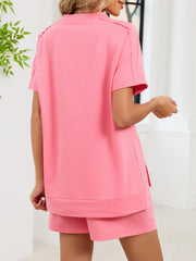 Pink relaxed two-piece set with short sleeves, crew neck, and side pockets on shorts.