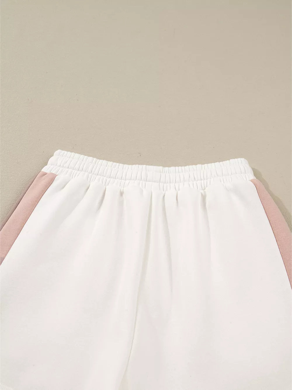 White cotton shorts with blush pink color block side stripes and elastic waistband.