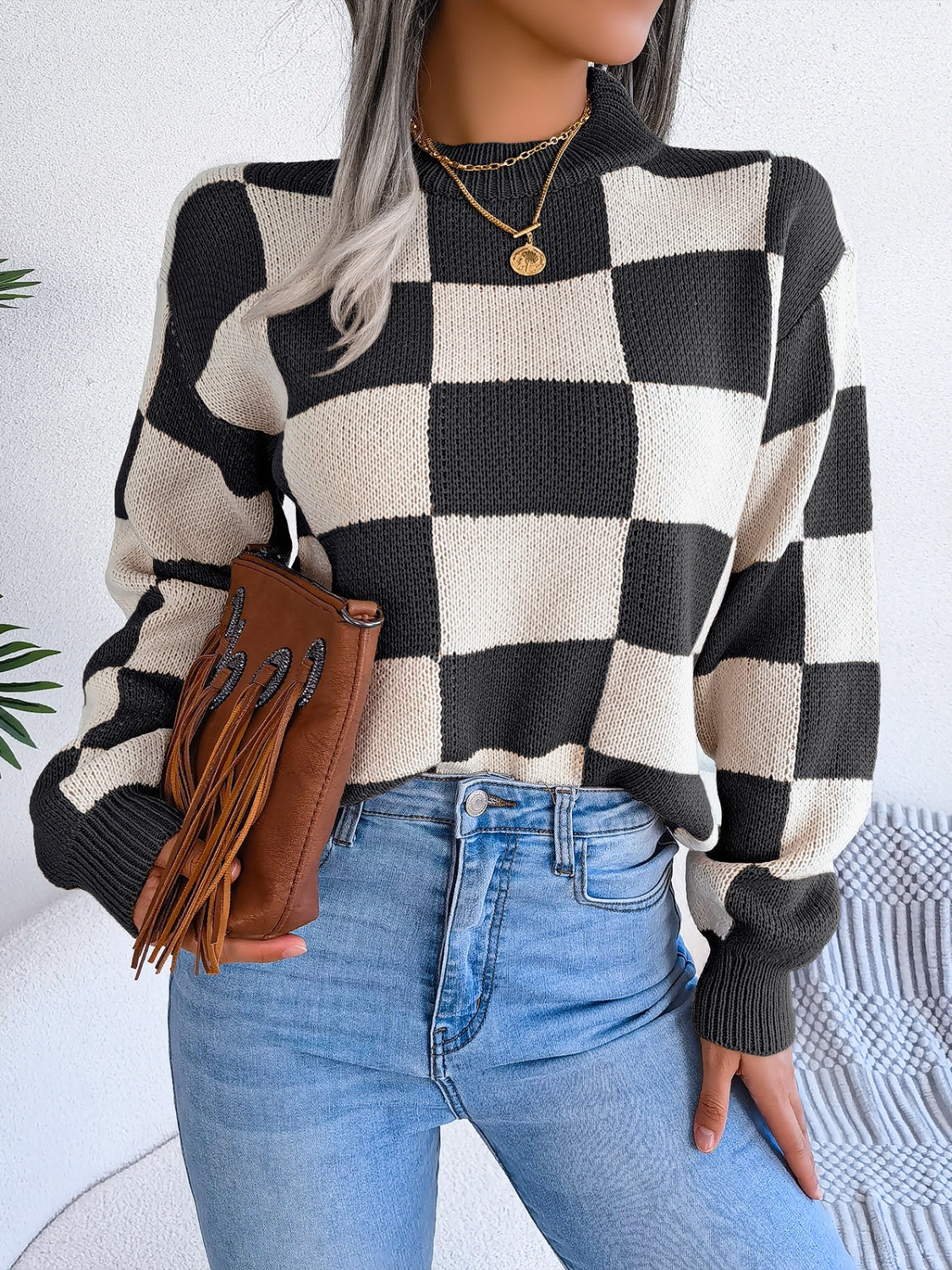 Checkerboard knit mock neck pullover sweater in black and cream acrylic with ribbed cuffs.