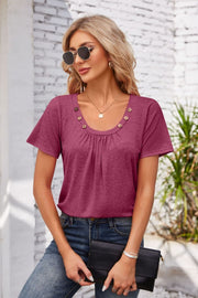 Button-trimmed gathered yoke top in watermelon pink with short sleeves and a scoop neckline.