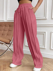 Pleated palazzo trousers in dusty pink with drawstring waist and wide legs.