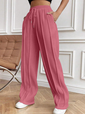 Pleated palazzo trousers in dusty pink with drawstring waist and wide legs.