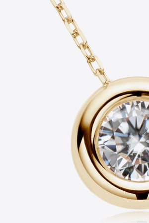 Gold necklace with bezel-set moissanite solitaire pendant and chain detail.