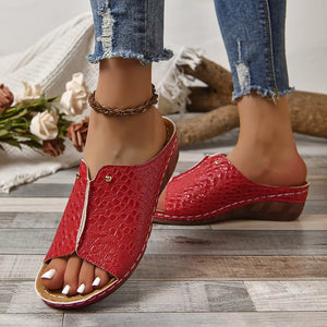 Red glossy crocodile-embossed wedge sandals with open toe and white stitching.