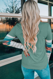 Sage crewneck shirt with Aztec print sleeves and striped details.