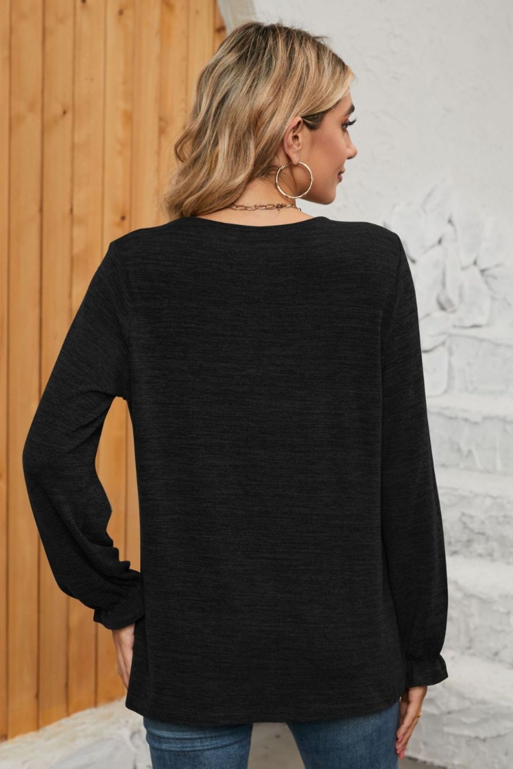 Black knit top with ruffled cuffs and long sleeves