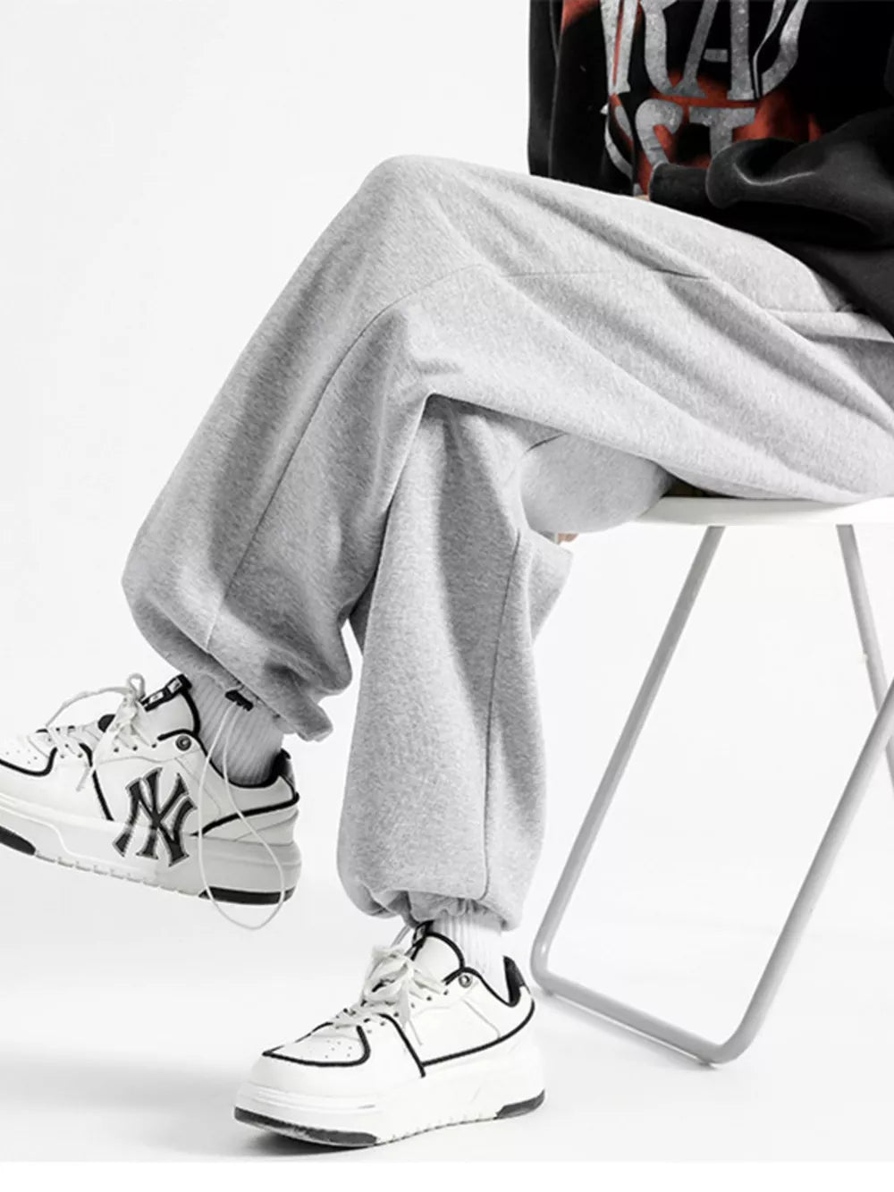 Light gray cotton sweatpants with a relaxed fit and wide leg, cuffed at the ankle.