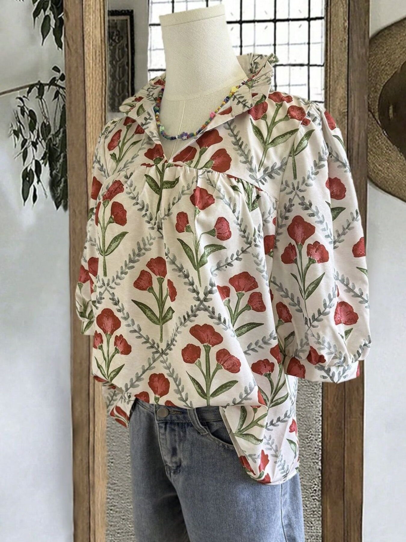 Ruffle collar blouse with red floral print and ruffled trim.
