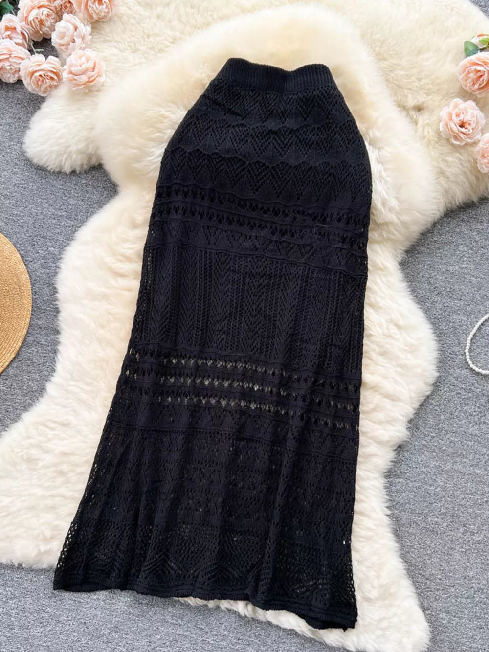 Black openwork maxi skirt with intricate woven details and a flared hem.