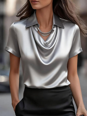 Luxurious grey satin cowl neck maternity shirt with short sleeves and a draped neckline.