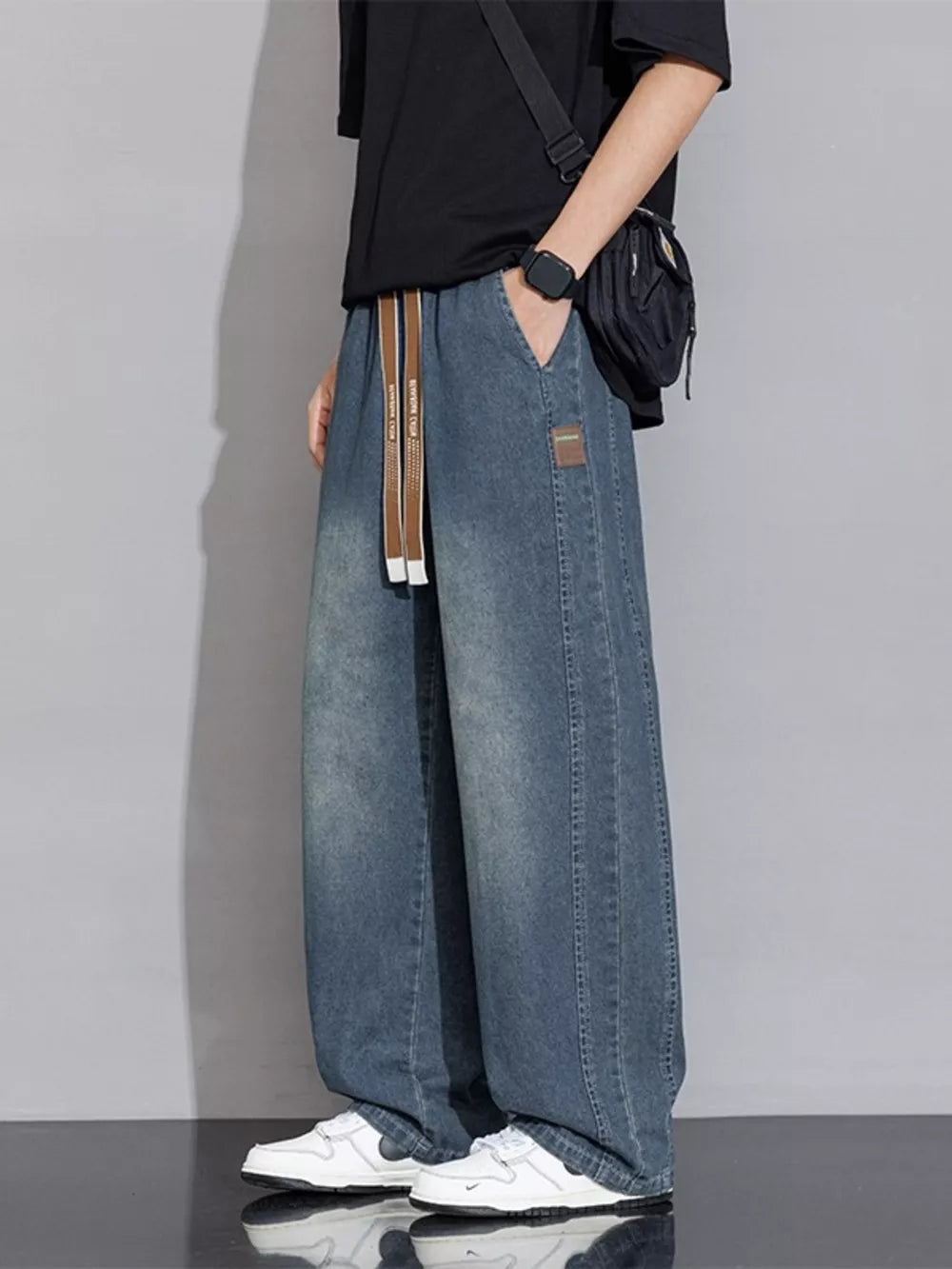 Relaxed vintage wash wide-leg jeans in gray blue denim with drawstring waist and patch detail.