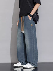 Relaxed vintage wash wide-leg jeans in gray blue denim with drawstring waist and patch detail.