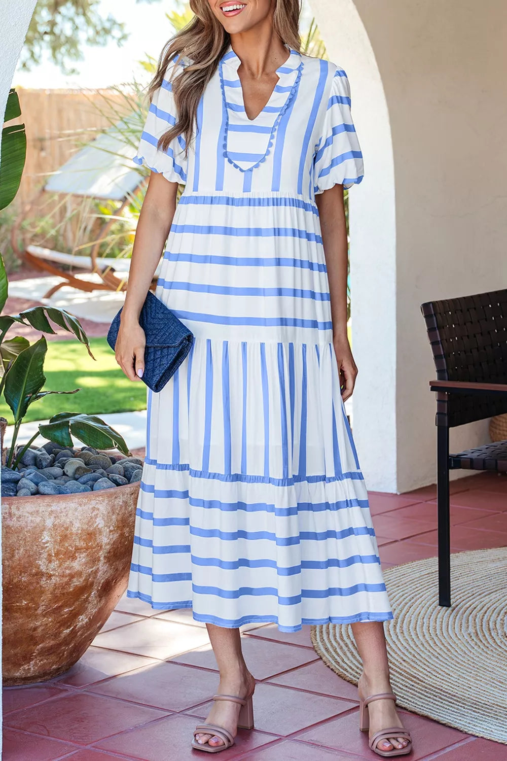 Tiered maxi dress with blue and white stripes, ruffled neckline, and short sleeves.
