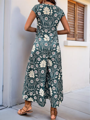 Dark green botanical print culotte jumpsuit with short sleeves and wide legs.
