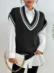 Black acrylic knit vest with white contrast trim, V-neck, sleeveless, layered over a white collared shirt.