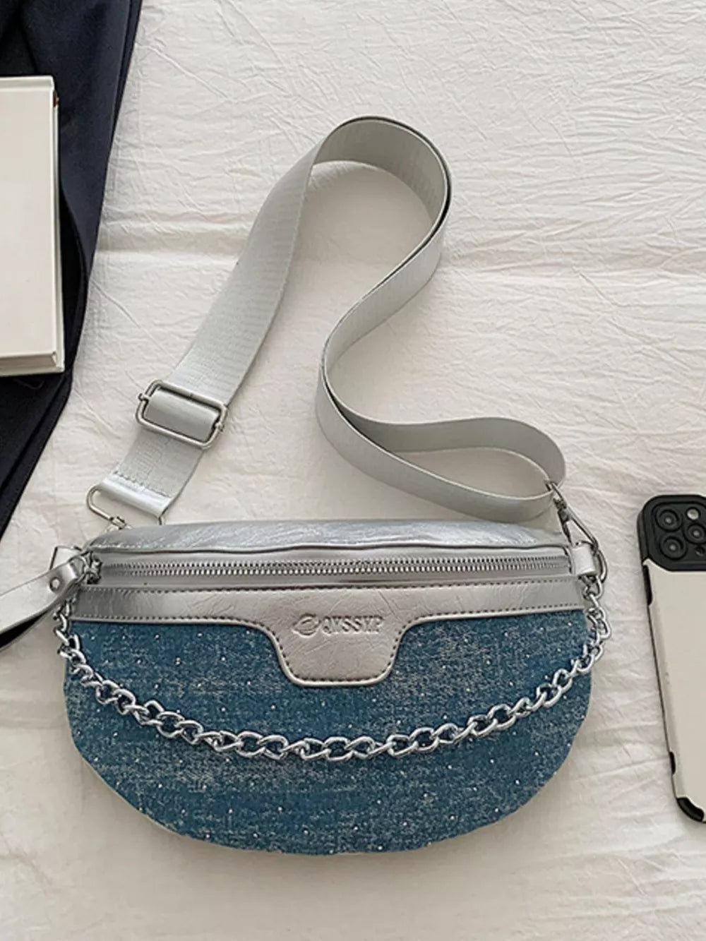 Crescent mini denim crossbody bag with silver accents and chain detail