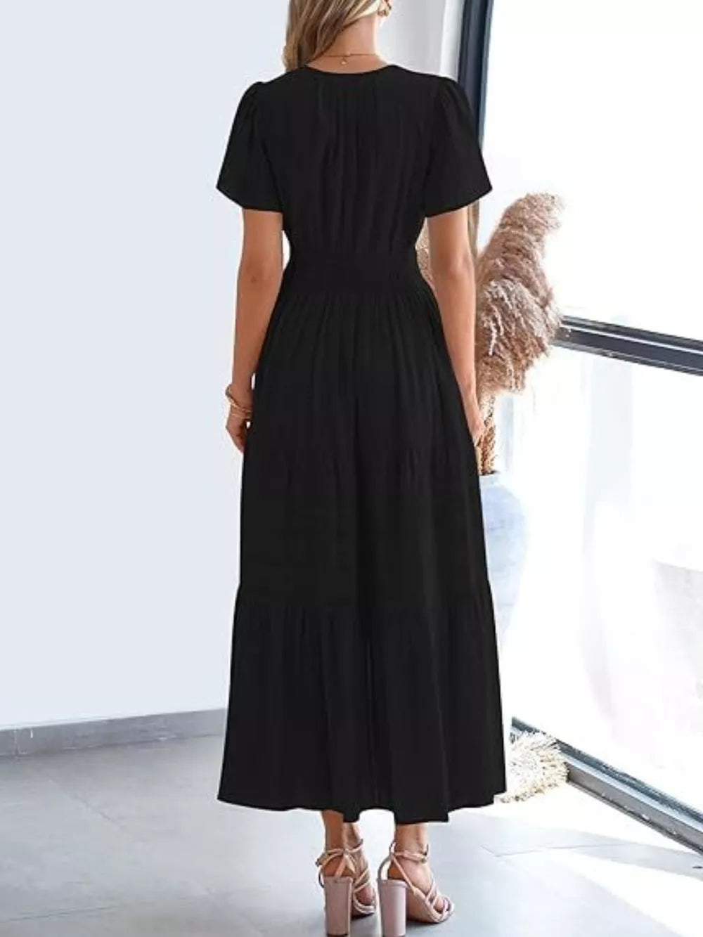 Black ruched V-neck tiered midi dress with short sleeves and smocked waist.