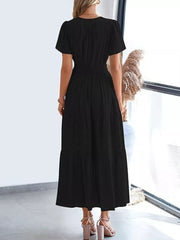 Black ruched V-neck tiered midi dress with short sleeves and smocked waist.
