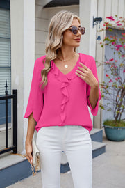 Hot pink V-neck blouse with ruffle detail and flutter sleeves.