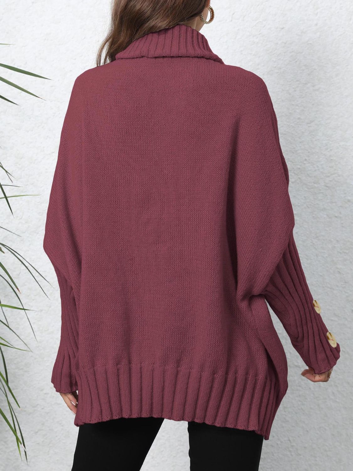 Burgundy turtleneck sweater with button cuff detail and slouchy knit design.