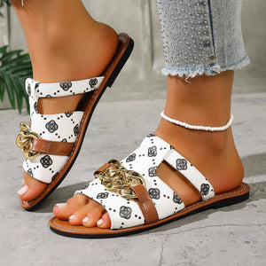 Patterned slide sandals in gray/white with chain accent and brown trim.