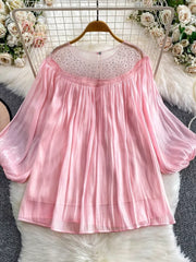 Pink sheer blouse with rhinestone-embellished neckline and balloon sleeves.