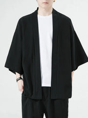 Black oversized casual open front jacket with short sleeves and a white t-shirt underneath.