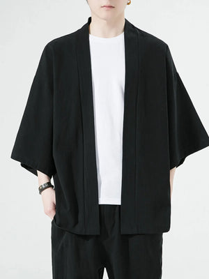 Black oversized casual open front jacket with short sleeves and a white t-shirt underneath.