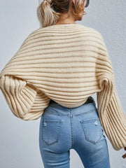 Beige ribbed knit cardigan with balloon sleeves and a cropped fit, styled with jeans.