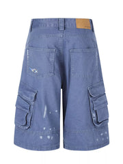Blue faded cargo capris with distressed paint splatters and stylish patch detail.