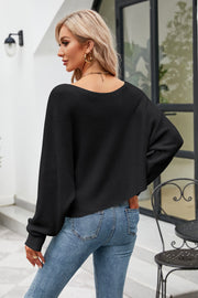 Black ribbed knit sweater with off-shoulder boat neck and balloon sleeves.