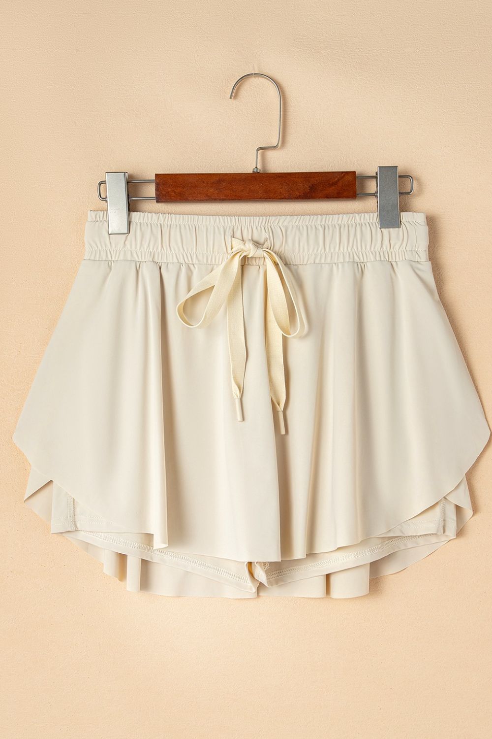 Beige ruffled skort with tie waist detail and elastic waistband.