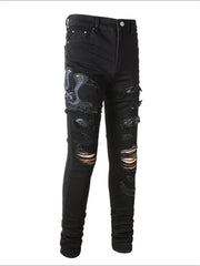 Black skinny jeans with embroidered cobra detail and distressed rips.