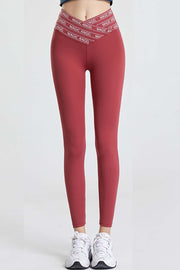 Red active leggings with a V-waistband and white logo band detail.